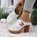 Detailed view of white hollow-out floral high heel clogs with a chunky platform sole - 36 / White