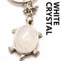 Porte-clés tortue élégant avec pierre de cristal blanc et finition argentée. - Cristal blanc