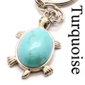 Detailed silver turtle keychain pendant featuring a polished natural turquoise stone inlay - Turquoise