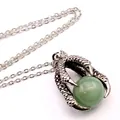 Detail view of a vintage silver dragon claw pendant holding a green aventurine gemstone bead. - Aventurine