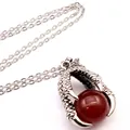 Macro detail showing retro medieval dragon claw pendant holding a red agate bead. - Dragon Claw Pendant (With Necklace) / Red Agate