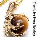 Gold-plated dragon claw pendant holding a round brown tiger eye stone bead on a chain - Tiger Eye with Necklace
