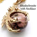 Gold-toned dragon claw pendant necklace featuring a round pink rhodonite stone bead - With Necklace / Rhodonite