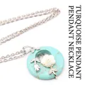 Turquoise donut pendant necklace with elegant white flower and silver leaf accents - Necklace Set / Turquoise