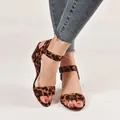 Stylish leopard print wedge sandals featuring an adjustable buckle ankle strap on model feet - Leopard Print