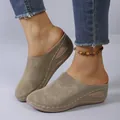 Detail view of khaki wedge mules featuring white contrast stitching and soft suede texture - 36 / Khaki