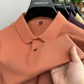 Close-up of orange-pink pique cotton polo shirt with mesh texture and button detail. - Orange
