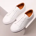 Detail view of premium white leather sneakers with soft orange interior lining - 38 / White