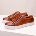 Close-up of premium brown leather sneakers with thick white soles and matching laces. - 38 / Brown