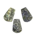 Detailed macro view of three hand-carved natural labradorite mermaid pendants on white - Mermaid