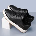Detailed view of black men's casual sneakers featuring premium cowhide leather and white soles - 36 / Black Lace-up