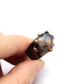 Vista detallada de un anillo vintage con piedra natural en forma de corazón entre los dedos - Heart-Shaped Labradorite Style