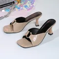 Detailed view of nude crocodile embossed square-toe high-heel sandals with gold hardware. - 35 / Nude