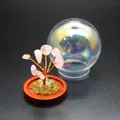 Detailed view of a miniature rose quartz tree of life with an iridescent glass dome - Rose Quartz
