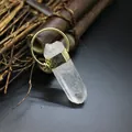 Macro shot of a raw clear crystal point pendant with a stylish gold-tone metal cap - Clear Quartz (Gold)