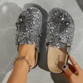 Detailed view of silver sequined clogs featuring black butterfly appliques. - 36 / Silver