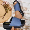 Detail view of denim blue platform slide sandals featuring a thick textured sole. - 36 / Denim Blue