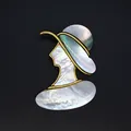 Détail d'une broche en nacre irisée avec une silhouette de femme dans un cadre doré. - Portrait de Dame (Style 6)