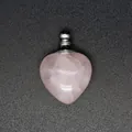 Dettaglio macro di un ciondolo bottiglia di profumo in quarzo rosa a forma di cuore - Quarzo rosa / Argento