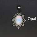Vintage oval opal pendant with intricate silver-toned filigree frame on black background. - Opal