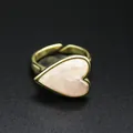 Close-up detail of a vintage gold heart ring with an elegant pink natural stone inlay - Rose Quartz