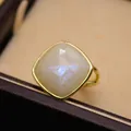 Primer plano de un anillo de piedra de luna natural con una montura dorada ajustable - Piedra lunar