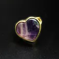 Detalle macro de un anillo de piedra natural púrpura en forma de corazón dorado - Fluorita púrpura
