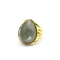 Detailed view of a gold-plated ring featuring a large pear-shaped iridescent gemstone. - Labradorite