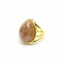 Macro view of teardrop-shaped peach quartz stone on a multi-strand gold-plated ring band - Sunstone