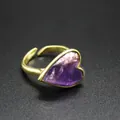Macro detail of a vintage heart ring featuring a purple natural stone on gold band - Amethyst