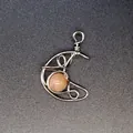 Handmade silver wire-wrapped moon pendant featuring a round peach sunstone inlay - Sunstone Moon Pendant / Silver