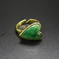 Macro view of a vintage gold-toned heart ring featuring a vibrant green natural stone inlay. - Green Strawberry Quartz