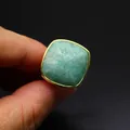 Primer plano detallado de un anillo de piedra natural verde cuadrada facetada con banda dorada - Amazonita
