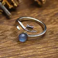 Macro detail of a silver open ring featuring a cute cat head and blue natural stone - Labradorite