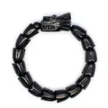 Detailansicht eines schwarzen Steinarmbands mit fein geschnitztem Drachenkopf und Blütenperlen - Obsidian