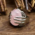 Detail of hand-shaped silver ring holding a large oval pink natural stone crystal - Rose Quartz