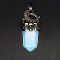 Vue détaillée d'un pendentif gothique lune et crâne avec un cristal d'opalite brillant. - Opale