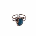Primo piano di un anello in rame vintage con una pietra di cristallo blu naturale grezza. - Apatite