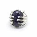 Detailed macro view of a silver hand-claw ring holding a sparkling blue goldstone. - Blue Sandstone