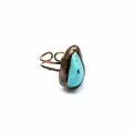 Dettaglio ravvicinato di un anello in rame stile medievale con pietra turchese grezza - Turchese
