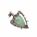 Close-up of a vintage bronze heart-shaped pendant featuring a green natural stone inlay - Aventurine Jade
