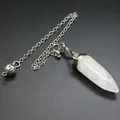 Detail view of a white bullet-shaped crystal pendulum pendant on a silver chain - White Crystal