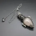Macro view of an antique silver cage pendulum pendant with a rose quartz crystal - Pendant With Pendulum Chain / Rose Quartz