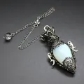 Detailed view of antique silver egg-shaped crystal pendulum pendant with ornate metalwork - Pendant With Pendulum Chain / Opal