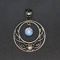 Detail of a vintage silver circular moon pendant with an intricate hollow knotwork design. - Opal
