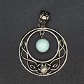 Detailed view of a silver hollow moon pendant featuring a natural pale blue stone. - Amazonite