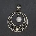 Detailed view of an antique silver circular moon pendant with a suspended white bead. - White Crystal