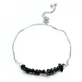 Détail de pierres naturelles noires sur un bracelet en chaîne argentée réglable - Obsidienne