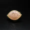 Macro detail showing the faceted strawberry quartz marquise-cut stone on a golden ring band - Strawberry Quartz / Adjustable Open