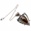Detailed macro view of retro tiger eye stone pendant with ornate bronze metal frame - Tiger Eye + Pendulum Chain